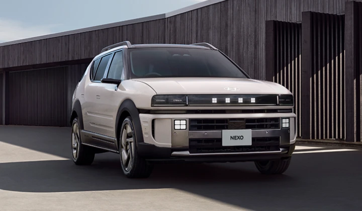 モダンな建築物を背景に建てられたThe all-new NEXOのフロントビュー - Hyundai Mobility Japan (ヒョンデ ジャパン)