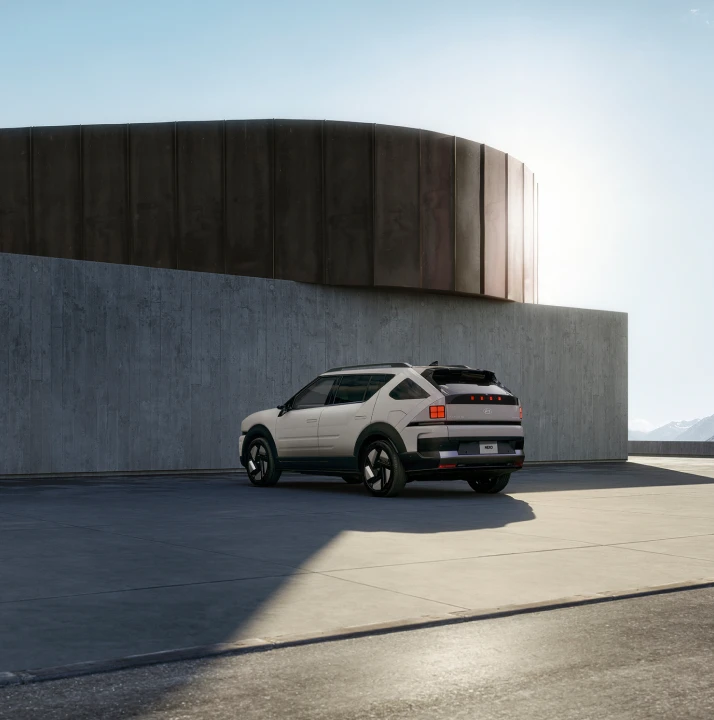 モダンな建築物の前に停まっているThe all-new NEXOサイド - Hyundai Mobility Japan (ヒョンデ ジャパン)