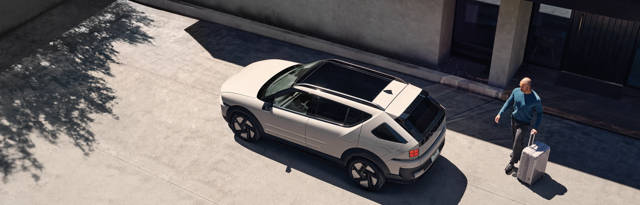 建物の横に駐車されたThe all-new NEXOを上から見下ろしたハイアングルショット - Hyundai Mobility Japan (ヒョンデ ジャパン)